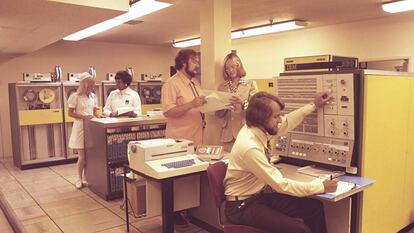 Foto de trabajadores médicos y enfermeras en una sala con un ordenador IBM de a principios de los 80.