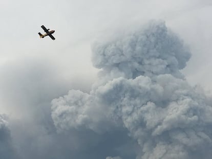 Un avión contra incendios pasa por encima de los incendios forestales en la zona cerca de Pedrogao Grande.