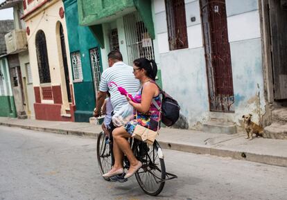 Tres personas comparten su bicicleta en una calle en Santa Clara (Cuba), el 1 de abril de 2018.