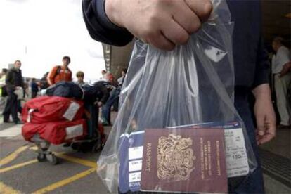 Un pasajero en el aeropuerto londinense de Heathrow acarrea una  bolsa de plástico como equipaje de mano.