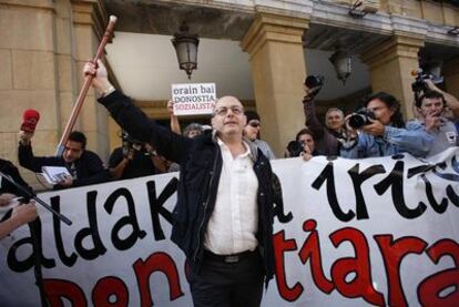 Juan Carlos Izagirre, de Bildu, levanta la makila para celebrar su elección como alcalde donostiarra junto a simpatizantes radicales que le recibieron fuera del Ayuntamiento.