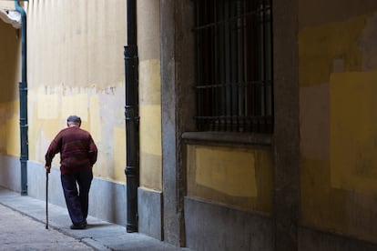 Un anciano camina con su bastón en Ávila.