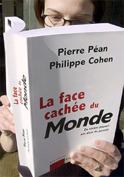 Un librero ojea en París un ejemplar de <i>La face cachée de Le Monde.</i>