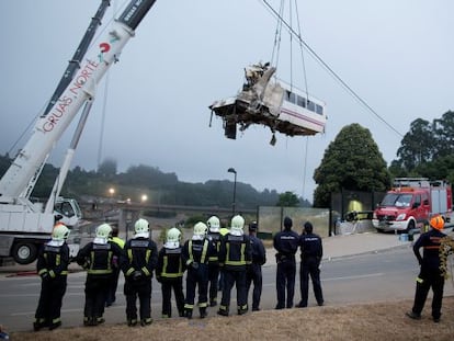 A wagon of a crashed train that killed at least 77 people is lifted at Angrois near Santiago de Compostela, Spain.