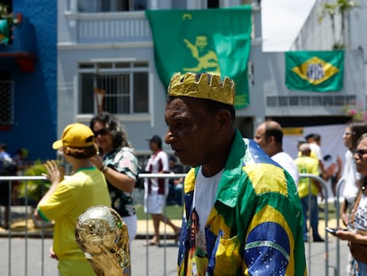 Un hombre sostiene una réplica de la Copa del Mundo, en la fila para dar el último adiós a Pelé, en Santos (Brasil), el 2 de enero de 2023.
