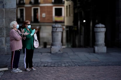 Dos mujeres, en la Plaza Mayor de Madrid, aplauden en homenaje al personal sanitario el 3 de mayo.