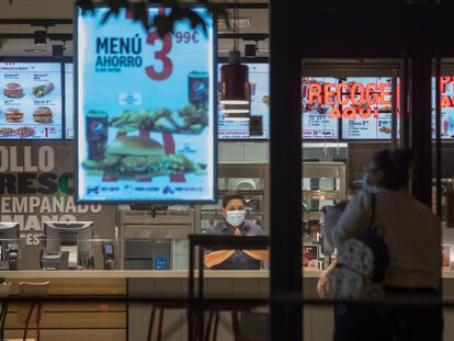 Una clienta se dispone a entrar en un restaurante de Madrid minutos antes del comienzo del estado de alarma.