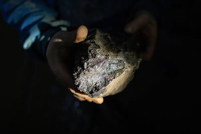 Um mineiro mostra um minério de cromita.