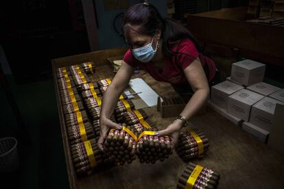 Una trabajadora empaqueta puros en la fábrica de puros Partagás en La Habana, Cuba, el jueves 11 de marzo de 2021.