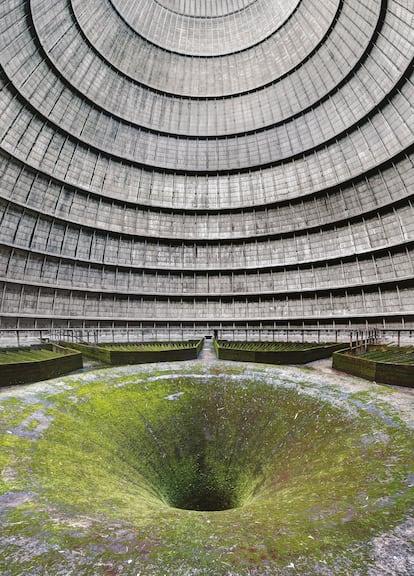 Torre de refrigeración de Monceau-sur-Sambre (Bélgica). Antes de montar la editorial Jonglez en 2003, Thomas Jonglez trabajó durante siete años en una empresa de aceros inoxidables. “Cuando visitaba las plantas industriales, me quedaba muy impresionado”, recuerda. De esa experiencia le ha quedado el gusto por las fábricas y el paisaje industrial en desuso, tan abundantes en los libros de ‘urbex’ que lleva publicados. En ‘Atlas de lugares abandonados’ figura, por ejemplo, esta torre de refrigeración situada en la localidad de Monceau-sur-Sambre. “Algunos lugares se convierten rápidamente en favoritos de la comunidad de exploradores y fotógrafos”, arranca Matt Emmett, autor de la fotografía publicada en el libro. “La construcción, situada en una bulliciosa ciudad industrial del centro de Bélgica, ofrece una experiencia emocionante y verdaderamente sensorial que justifica con creces su inmensa popularidad”, añade. Se sitúa junto a una central eléctrica abandonada, con un canal y una esclusa separando ambos espacios. La torre de refrigeración enfría y recircula el agua hervida para producir el vapor que mueve las turbinas de la central.