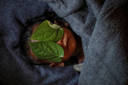 Rosto de um menino de 11 meses é coberto com folhas da pimenteira 'piper betle' depois de morrer lutando contra febre alta e tosse no campo de refugiados de Balukhali, perto do Cox's Bazar (Bangladesh), em 4 de dezembro de 2017.