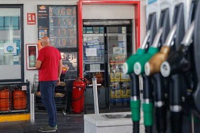Un hombre mira los precios de una gasolinera.