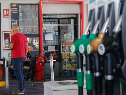 Un hombre mira los precios de una gasolinera.