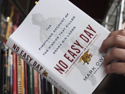 Un hombre hojea el libro 'Un Día Difícil' sobre la muerte de Osama Bin Laden.