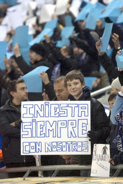 Un joven aficionado blanquiazul, con un cartel dedicado a Iniesta.