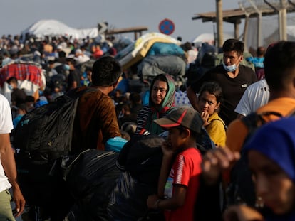 Refugiados y migrantes provenientes del campo de Moria hacen fila para entrar en un nuevo campo temporal, este viernes en la isla de Lesbos (Grecia).