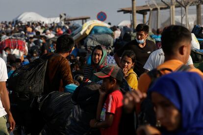 Refugiados y migrantes provenientes del campo de Moria hacen fila para entrar en un nuevo campo temporal, este viernes en la isla de Lesbos (Grecia).