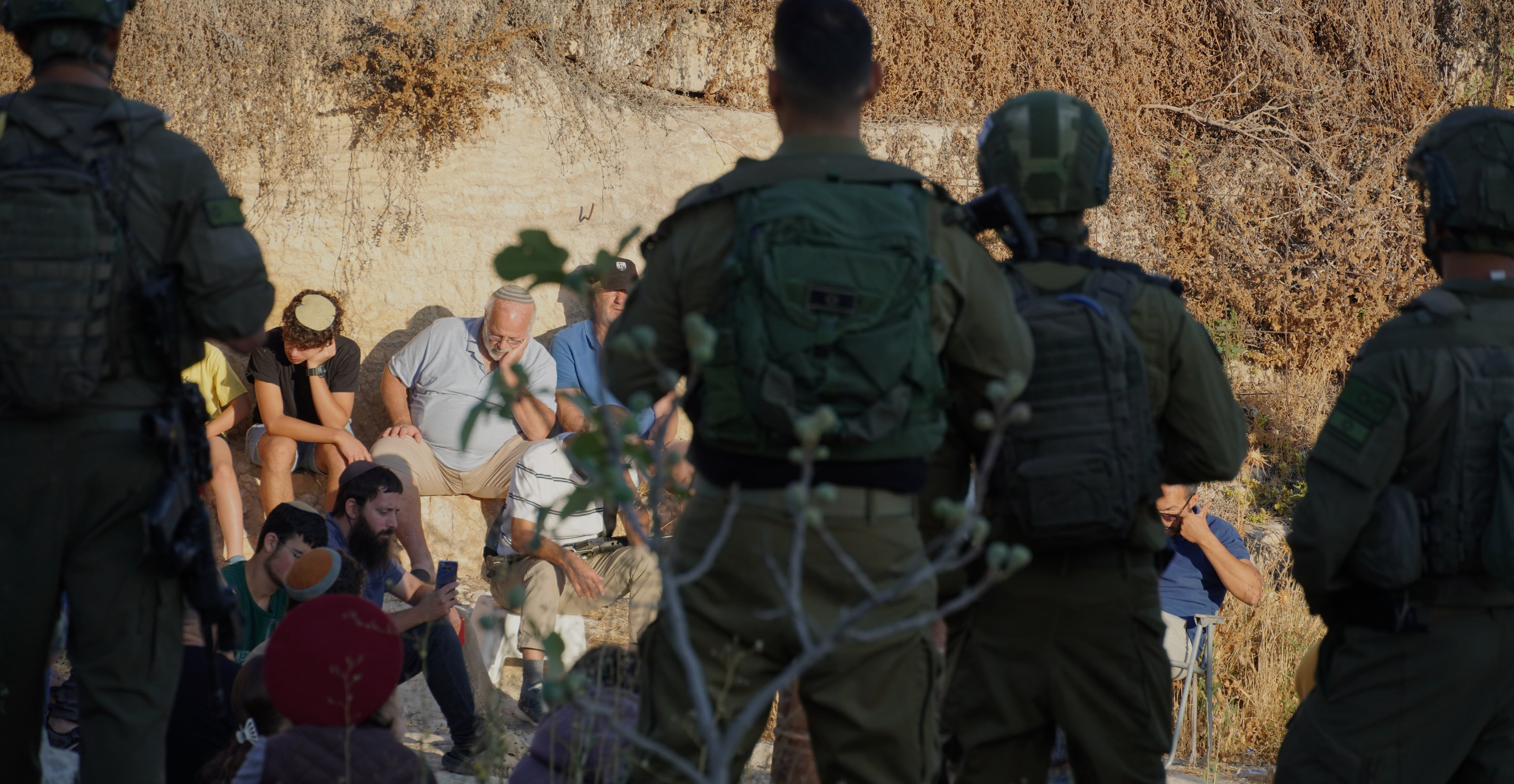 Momento del rezo judío colectivo, vigilado por soldados israelíes, este jueves en Al Tuwani, en el sur de Cisjordania. 
