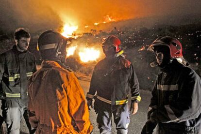 Varios bomberos hacen un alto durante la lucha contra el fuego en Fornelos.