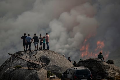 Varias personas observan el incendio forestal declarado en Avión (Ourense), este lunes.