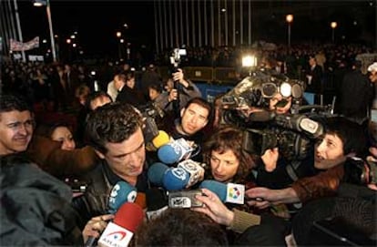 Julio Medem, a su llegada a la gala de los Goya. Al fondo, los manifestantes convocados por la Asociación Víctimas del Terrorismo.