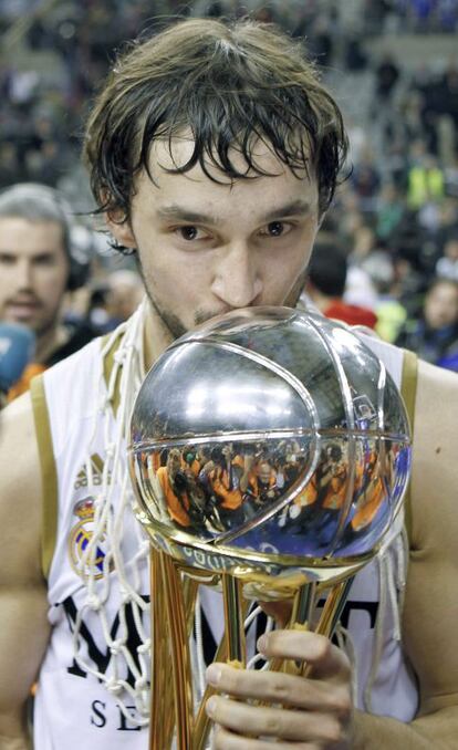 El base del Real Madrid Sergio Llull besa el trofeo de campeón