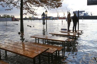 Dos personas observan las inundaciones subidos al tablero de una mesa en Hamburgo el 29 de octubre. Los bomberos recibieron hasta 550 avisos hasta la mañana del 29 de octubre debido a la tormenta, aunque la intensidad de las ráfagas disminuyó en las últimas horas.