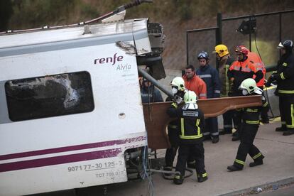 Los bomberos inspeccionan uno de los vagones siniestrados en el accidente, 25 de julio de 2013.