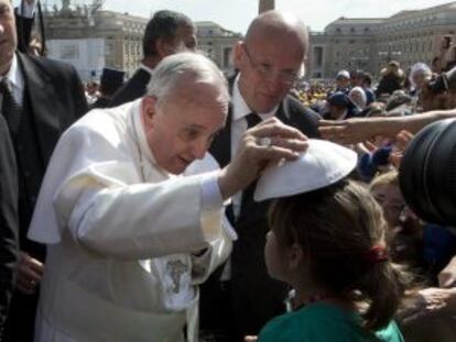 El papa Francisco en un gesto de complicidad con una niña.