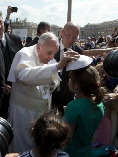 El papa Francisco en un gesto de complicidad con una niña.