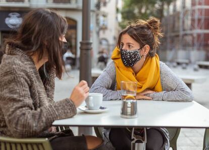 Tomando café en la calle con mascarilla.