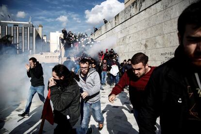 Varios manifestantes huyen del gas lacrimógeno lanzado por policías antidisturbios al final de una protesta contra las nuevas reformas sobre subastas inmobiliarias y huelgas laborales, en el exterior del Parlamento en Atenas (Grecia).