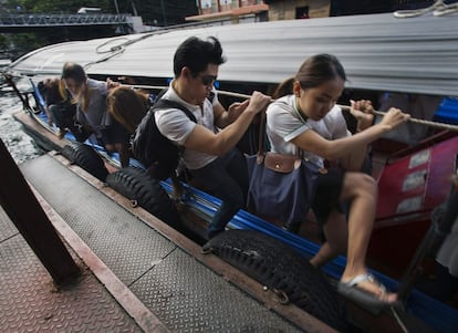 Unos pasajeros se bajan de una embarcación a motor en el muelle del canal Saen Saeb en Bangkok (Tailandia).