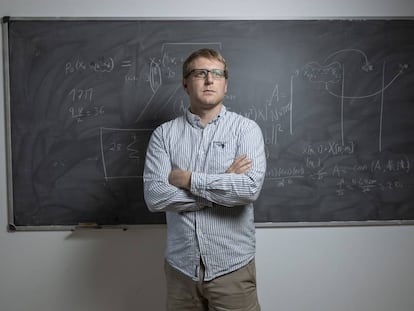 El matemático de Minesota, Jared Aurentz, en una sala del Instituto de Ciencias Matemáticas de Madrid. En la pizarra, partes de las fórmulas que representan la inteligencia artifical que aprende las reglas del dominó.