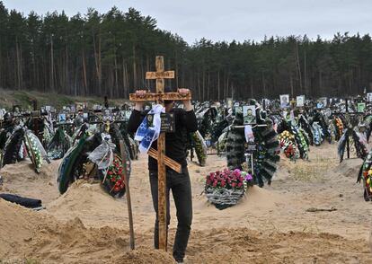 Un hombre coloca una cruz en una tumba durante un funeral en Irpin, este martes. El ministro de Exteriores de Ucrania, Dmytro Kuleba, ha afirmado este miércoles que el rechazo de ciertos países europeos a la entrega de armas a Ucrania implica 'de facto' un apoyo a "la agresión rusa y el exterminio" de los ucranios. 