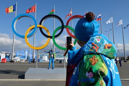 Uos voluntarios se hacen fotos bajo los anillos olímpicos en la villa olímpica de Sochi. 