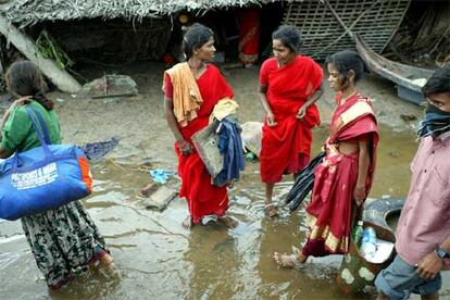 Una familia de la ciudad india de Karamawadi, a 350 kilómetros de Madras, uno de los lugares más golpeados por la catástrofe, abandona su casa con las pocas pertenencias que puede llevar consigo.