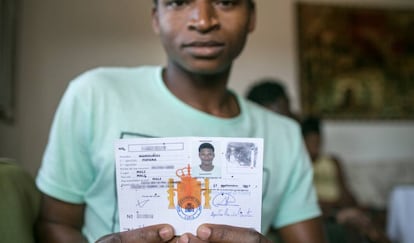 Un joven que llegó de Mali como menor muestra su documentación.