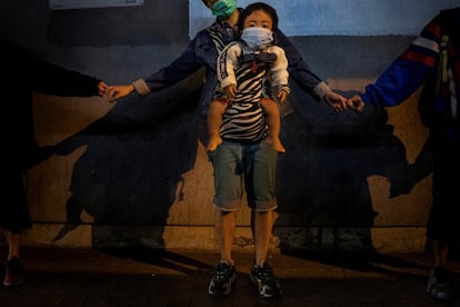 Una madre con su bebé participa en una cadena humana en señal de solidaridad en Kowloon Bay en Hong Kong, el 30 de noviembre de 2019.