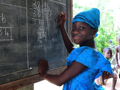 Fatimata Bagayogo (11 años) estudia en casa durante la pandemia, en Odienné, Costa de Marfil. Como las escuelas están cerradas, ella asiste a clases por televisión y practica matemáticas en una pizarra.