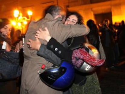 Dos italianos celebran la marcha de Berlusconi a las puertas del palacio presidencial, en Roma. 