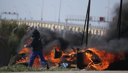 Un trabajador lanza una piedra durante las protestas con motivo de la cumbre iberoamericana.