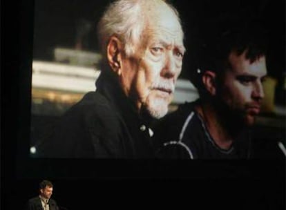 Paul Thomas Anderson se dirige al público. Al fondo una gran foto de Altman presidiendo la ceremonia.