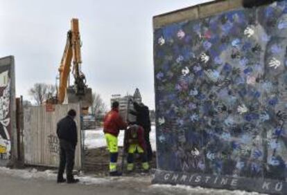 Una grúa trabaja en la controvertida obra de construcción de un edificio de apartamentos justo al lado de una sección del antiguo Muro de Berlín, en Alemania, hoy, miércoles 27 de marzo de 2013.