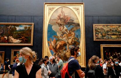 Visitantes con mascarilla en el Museo del Louvre de París.