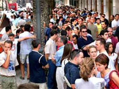 Cientos de personas hacen cola para comprar acciones del Valencia, en la calle de las Barcas de Valencia.
