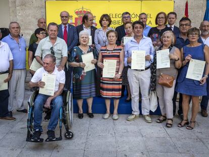 Los familiares de los represaliados con sus certificados este jueves en Valencia con la ministra de Justicia, Dolores Delgado.