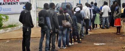 Trabalhadores da saúde da Libéria fazem fila para entrar em uma clínica de tratamento do ebola.