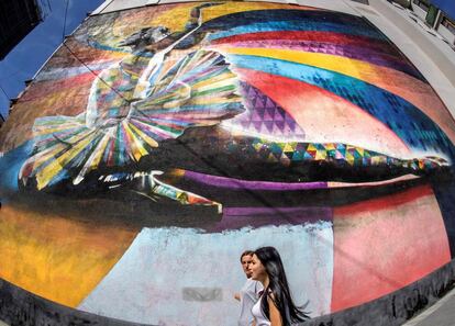 Dos mujeres pasan junto a un mural del artsiat brasileño Eduardo Kobra que muestra a la bailarina rusa Maya Plisetskaya, en Moscú (Rusia).