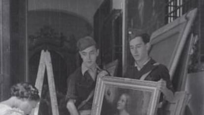 Una mujer hace el inventario de los cuadros de Las Descalzas Reales con dos soldados republicanos en 1936.